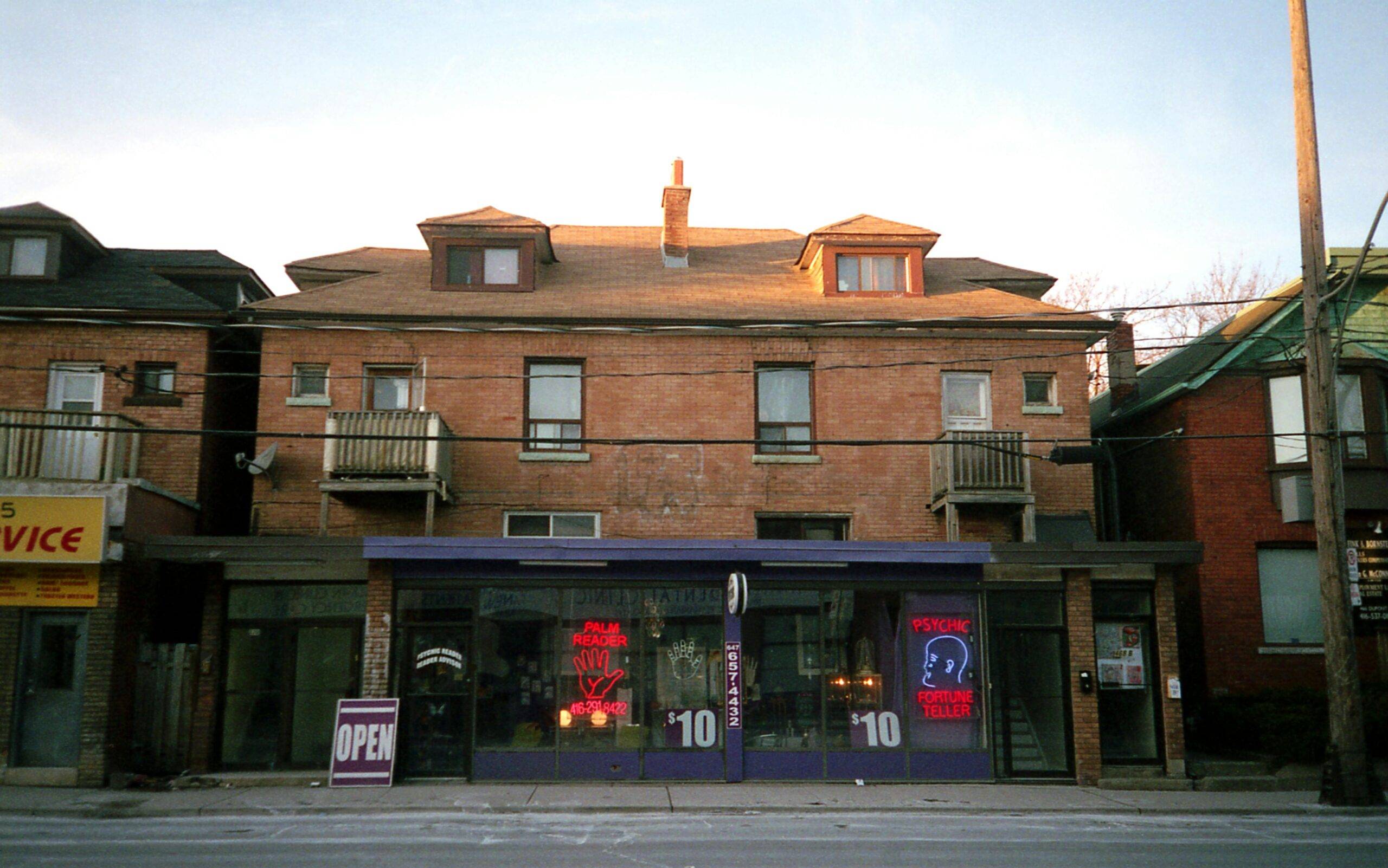 Brick building with a psychic shop in Toronto, Canada, showcasing urban charm.